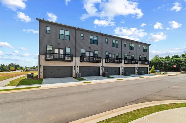 a front view of a building with a garden and plants