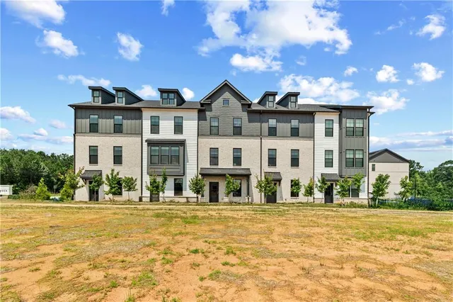 a front view of residential houses with yard and green space