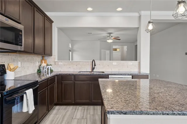 a kitchen with a sink stove and microwave