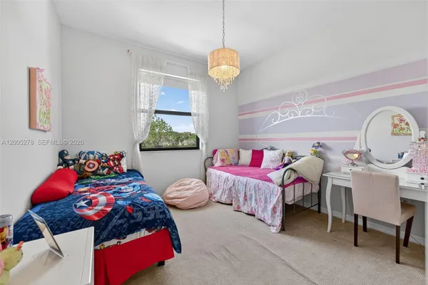 a bedroom with bed and a chandelier