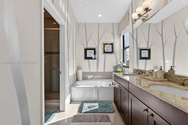 a large bathroom with a granite countertop sink a mirror a vanity and a shower