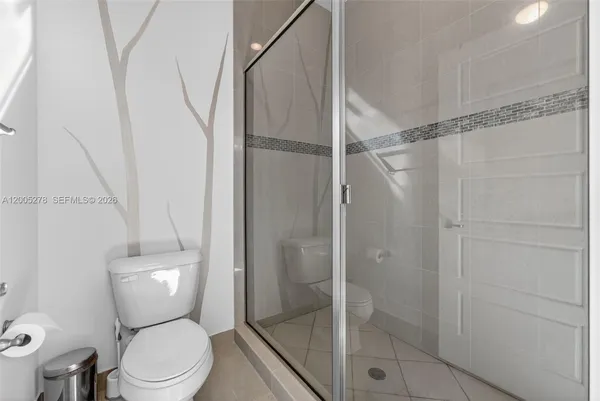 a white toilet sitting next to a shower