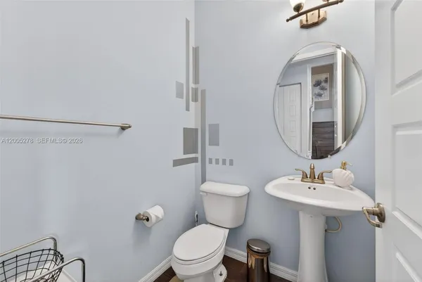 a bathroom with a toilet a sink and mirror