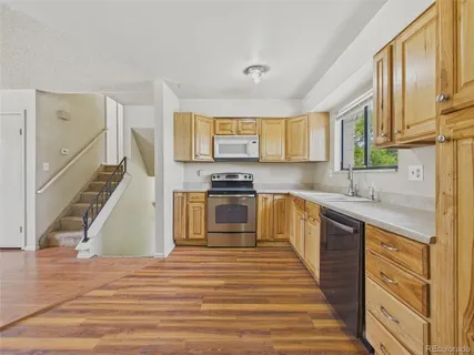 a kitchen with granite countertop a stove and a wooden floors