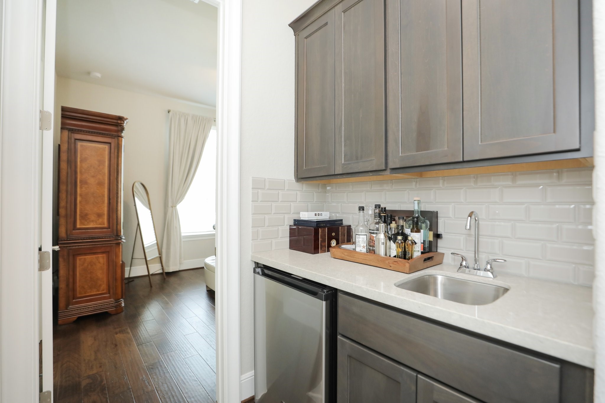 8511 Tynan Ridge Drive Magnolia, TX 77354 - Photo 31 of 50 Now let’s head into the guest suite area, ideal for visiting family, a second home office, or even a dedicated homeschool space, complete with its own private entry. You'll love the convenient beverage center featuring a sink and beverage fridge, perfectly positioned between the bedroom, bathroom, and an additional living area or flexible space your fmaily may need.