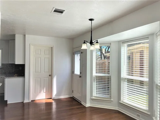 a view of a hallway with wooden floor and a window
