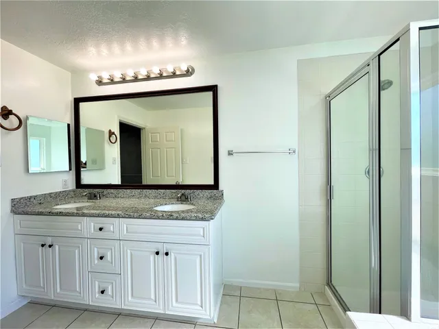 a bathroom with a granite countertop sink vanity and a mirror