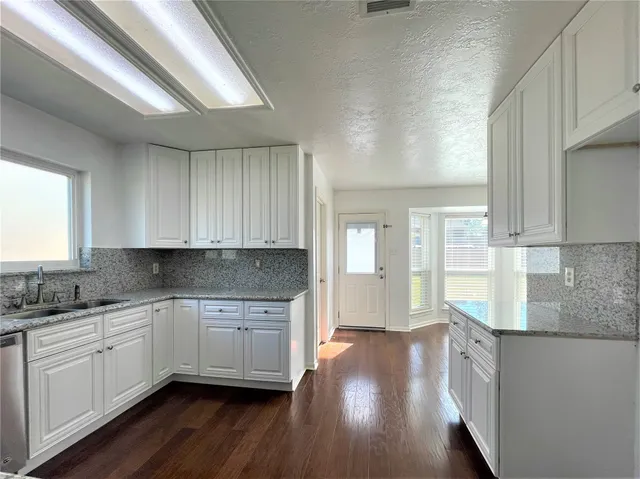 a kitchen with a sink window and cabinets