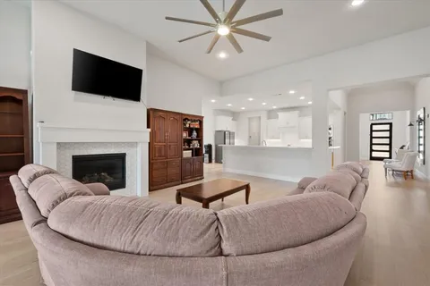 a living room with furniture a large window and a fireplace