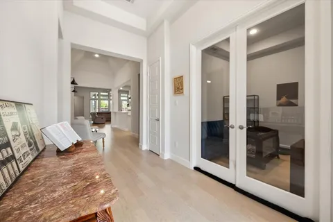 a kitchen with kitchen island a stove a sink a refrigerator and white cabinets