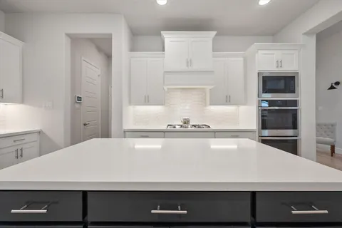 a view open kitchen with a sink and mirror