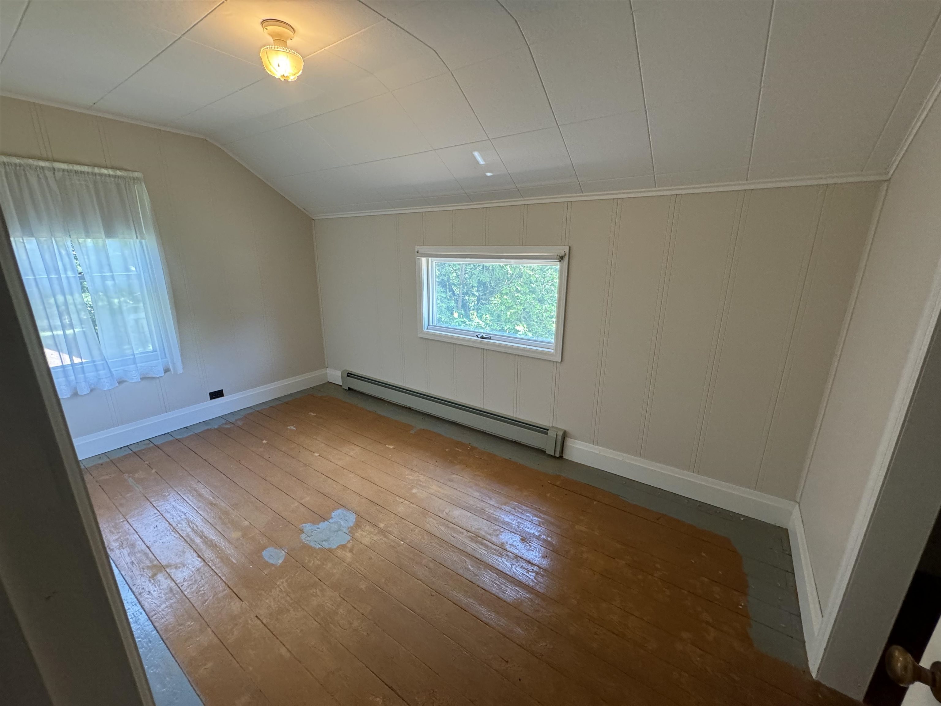 68520 Lea Street Iron River, WI 54847 - Photo 15 of 17 Interior space with a baseboard heating unit, vaulted ceiling, and hardwood / wood-style flooring