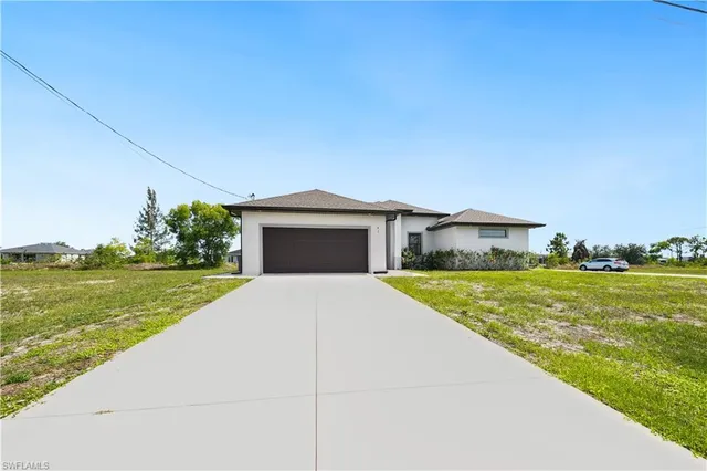 a front view of a house with a yard and lake view