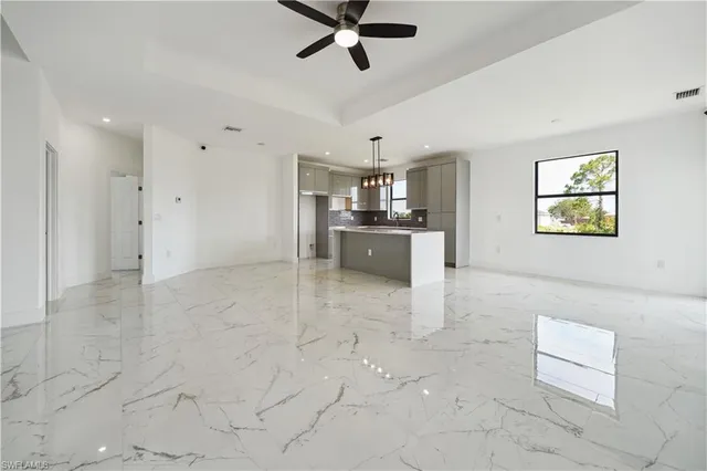 a large kitchen with granite countertop a sink a counter space appliances and cabinets