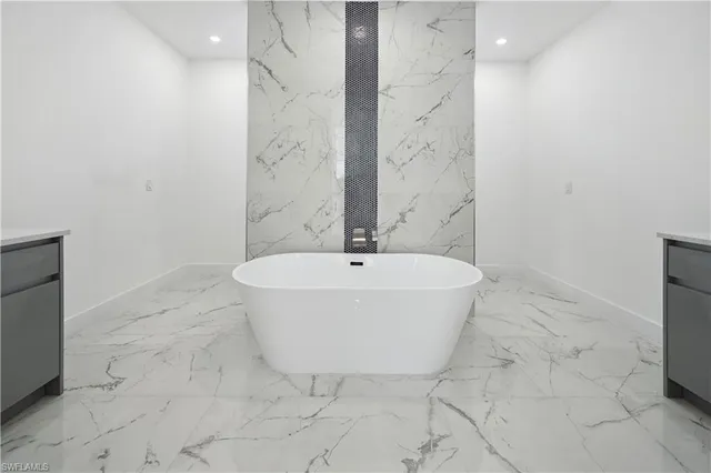 an empty room with windows and ceiling fan