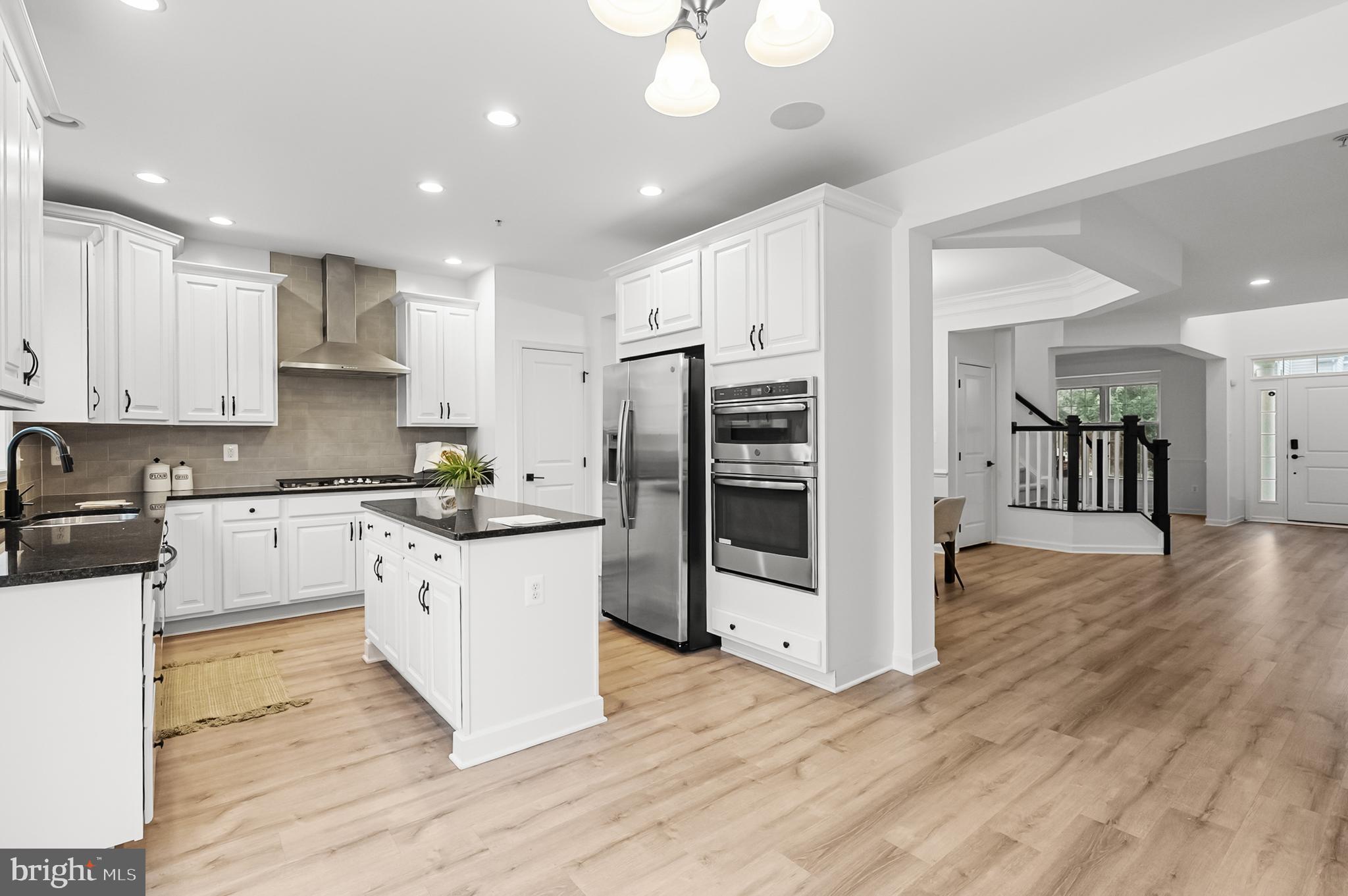 4603 Thoroughbred Drive Upper Marlboro, MD 20772 - Photo 19 of 64 a kitchen with stainless steel appliances granite countertop a refrigerator a stove oven and white cabinets with wooden floor