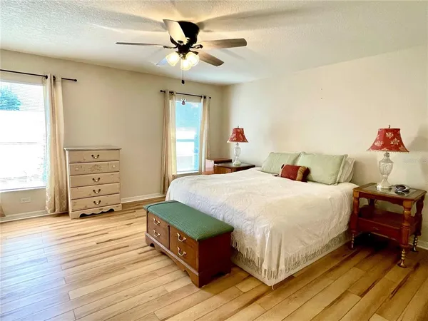 a spacious bedroom with a bed and a chandelier