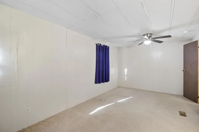 an empty room with chandelier fan