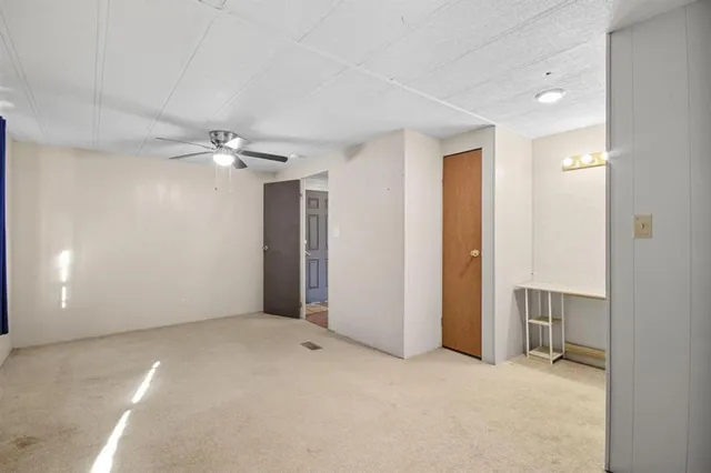 a view of a big room with closet and a ceiling fan