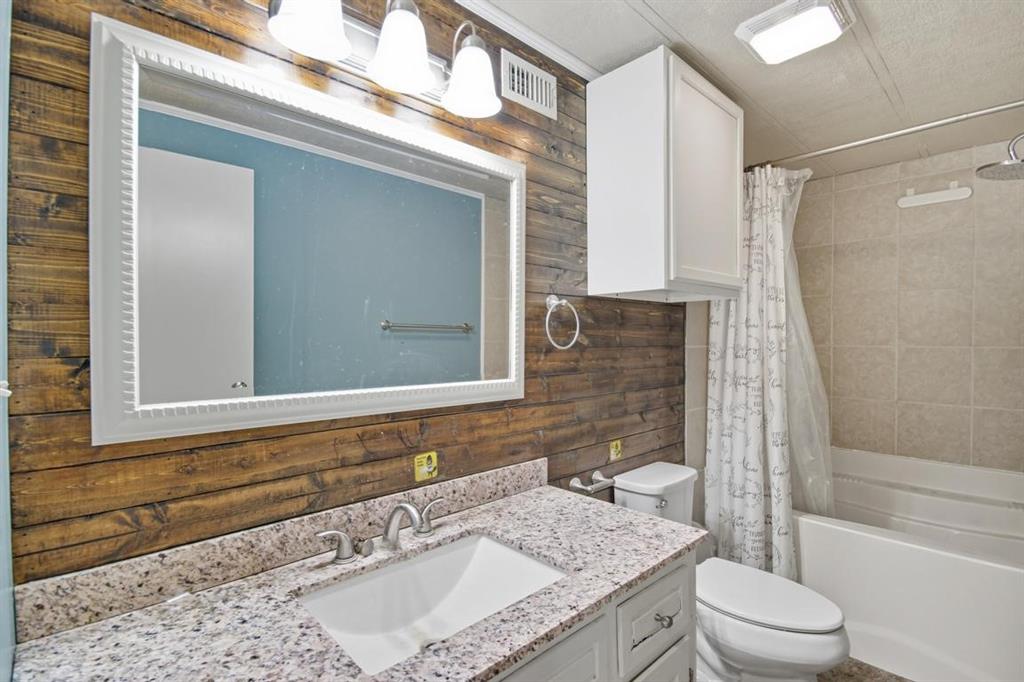 413 Charnel Street Clyde, TX 79510 - Photo 19 of 31 a bathroom with a granite countertop sink toilet and shower