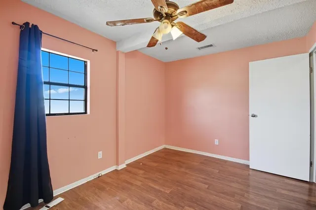 an empty room with a window and a fan
