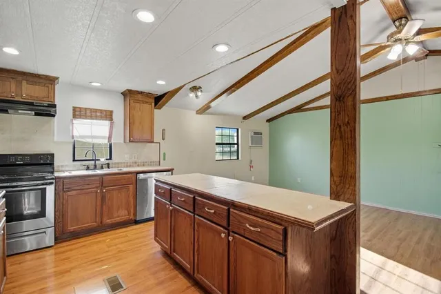 a kitchen with a stove sink and cabinets