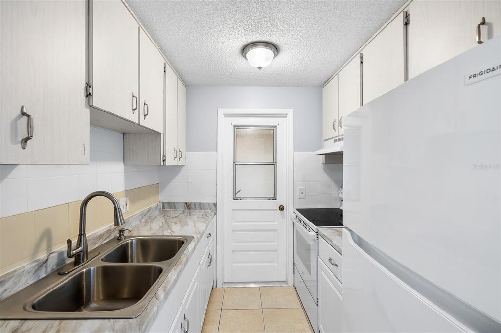 4930 Hazner Street New Port Richey, FL 34652 - Photo 8 of 22 a kitchen with white cabinets and a sink