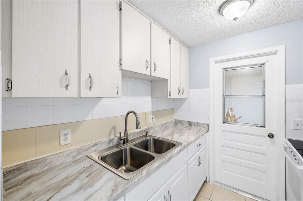 4930 Hazner Street New Port Richey, FL 34652 - Photo 9 of 22 a kitchen with white cabinets and a sink