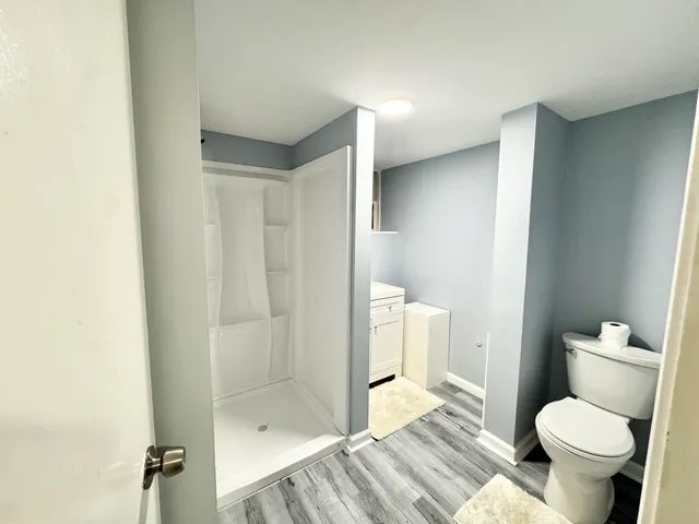 a bathroom with a granite countertop toilet and a shower
