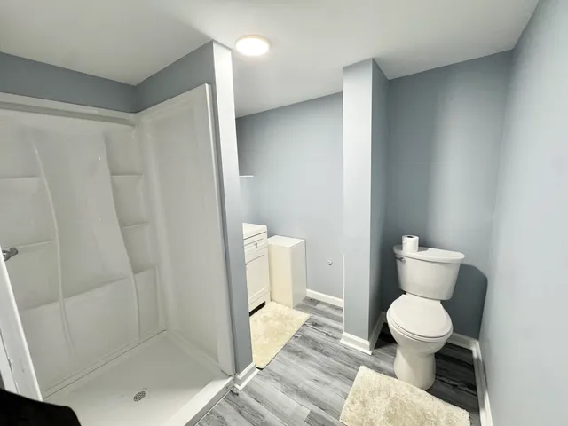 a bathroom with a toilet and a shower