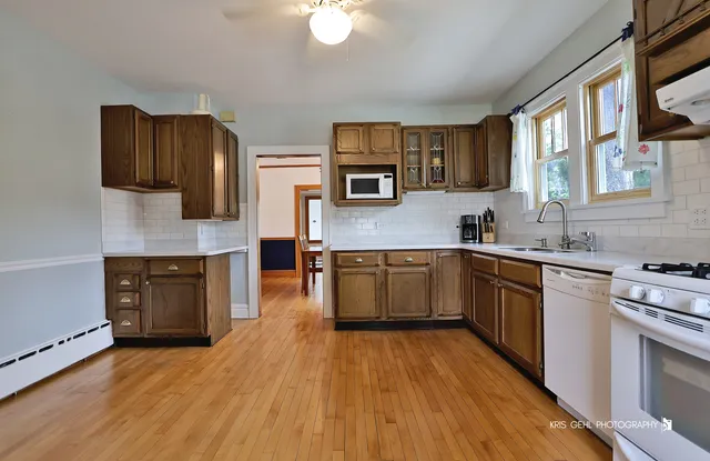 a kitchen with stainless steel appliances granite countertop wooden cabinets a stove top oven a sink and dishwasher