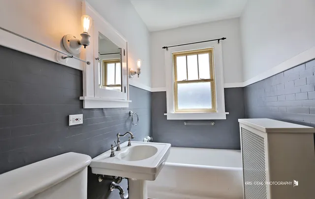 a bathroom with a sink a bathtub and a window