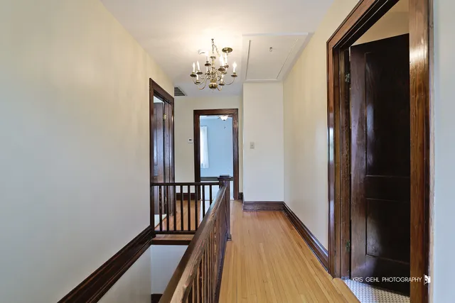 a view of a hallway with wooden floor and staircase