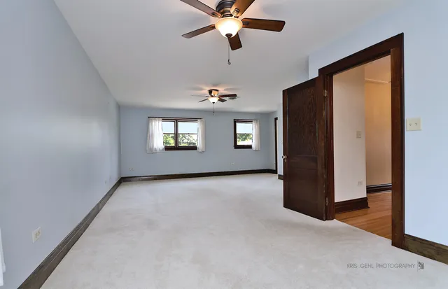 a view of an empty room with a window and a ceiling fan