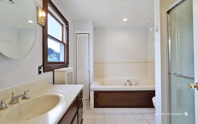 a bathroom with a tub sink and mirror