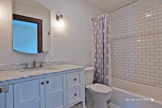 a bathroom with a granite countertop toilet sink and mirror