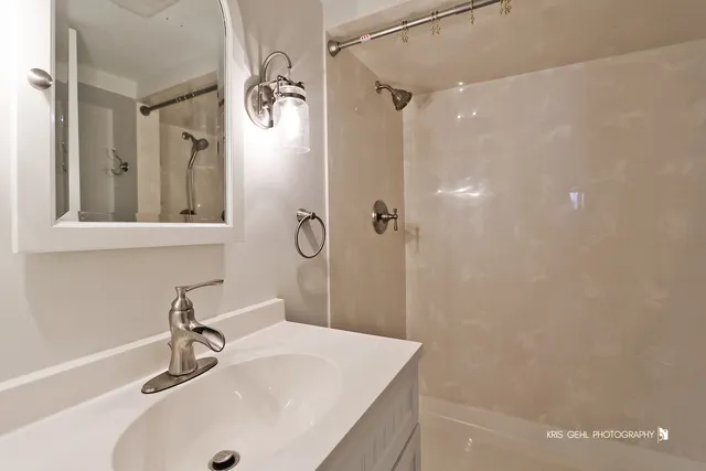 a bathroom with a sink a mirror and shower