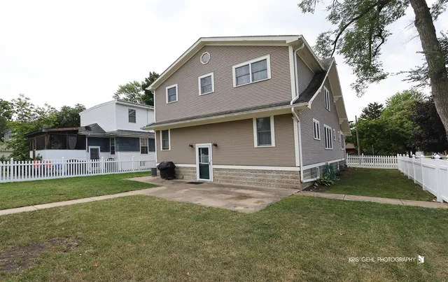 a view of a house with a yard and sitting area