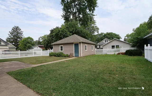 a view of a house with a yard and fence