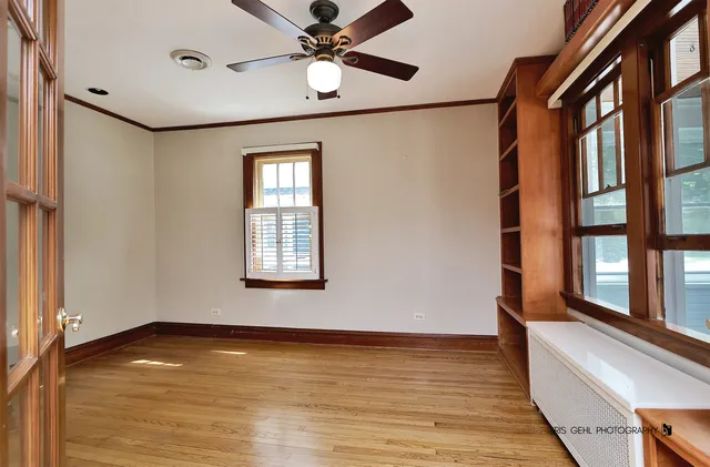 a view of an empty room with window and wooden floor