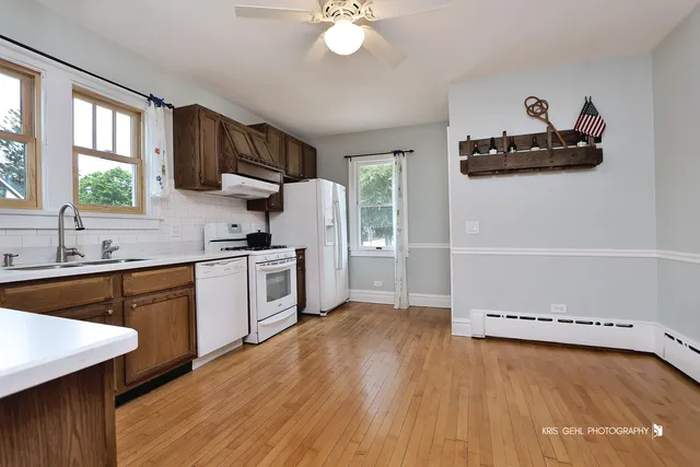a kitchen with granite countertop a stove a sink and a refrigerator