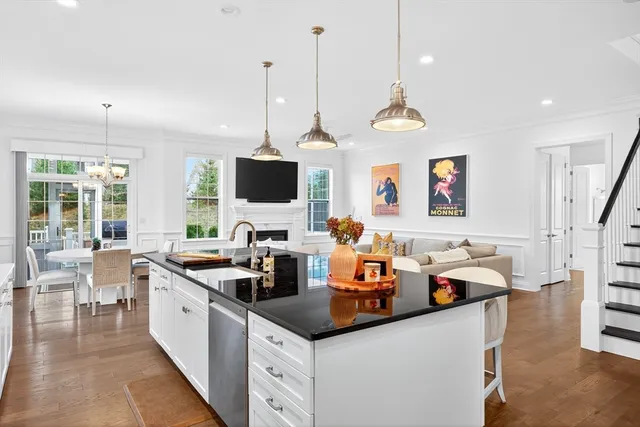 a kitchen with stainless steel appliances granite countertop a sink and a wooden floors