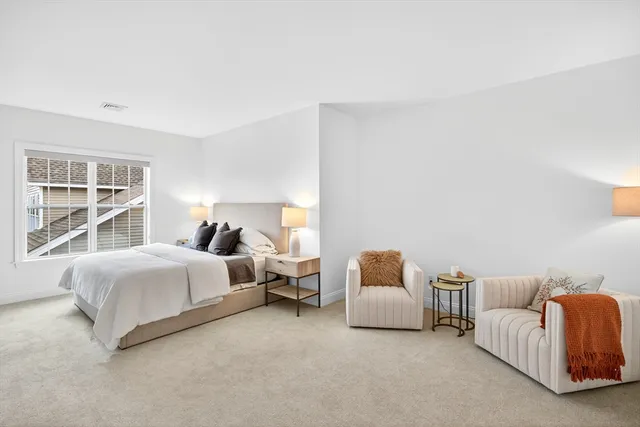 a spacious bedroom with a bed and a large window