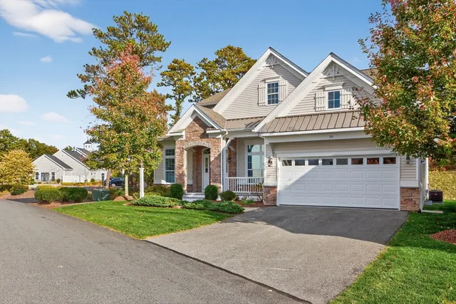 a front view of a house with a garden and trees