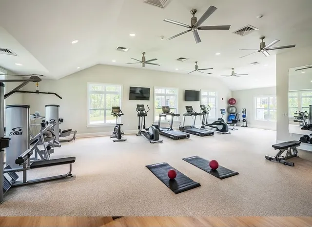a living room with furniture gym equipment and view of kitchen