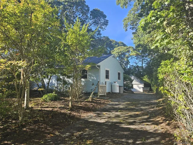 a view of a house with backyard and trees