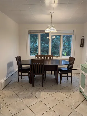 a dining room with furniture a chandelier and window