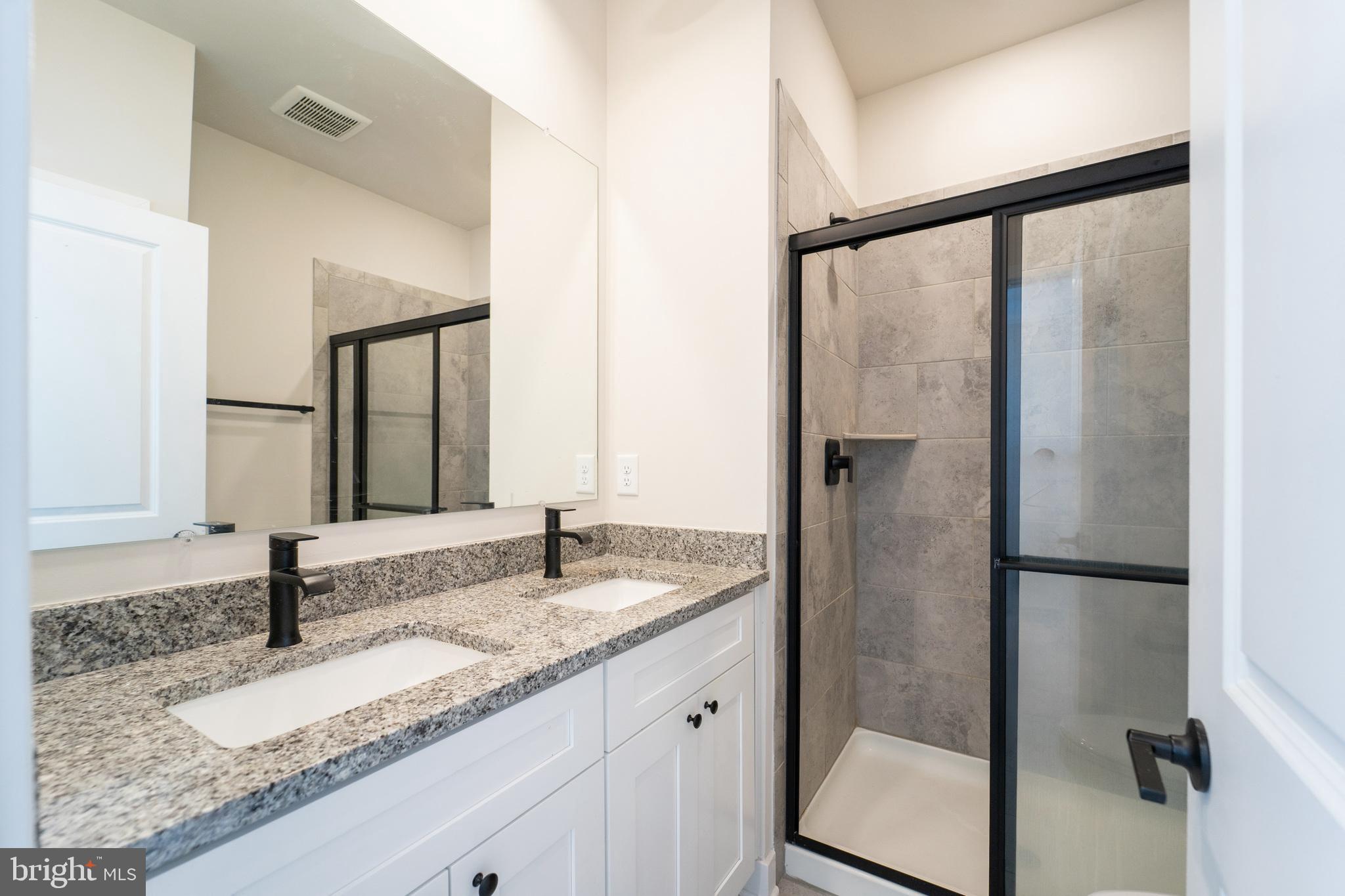 4334 Roland Heights Avenue Baltimore, MD 21211 - Photo 20 of 32 a bathroom with a granite countertop sink and a mirror