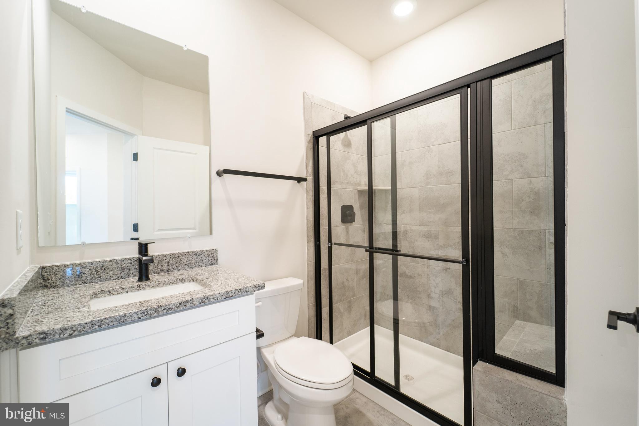 4334 Roland Heights Avenue Baltimore, MD 21211 - Photo 25 of 32 a bathroom with a granite countertop sink toilet and shower