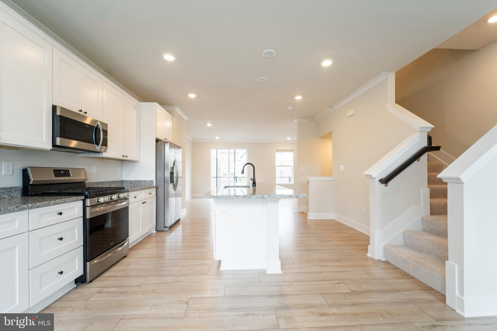 4334 Roland Heights Avenue Baltimore, MD 21211 - Photo 5 of 32 a large kitchen with stainless steel appliances granite countertop a stove and a wooden floors